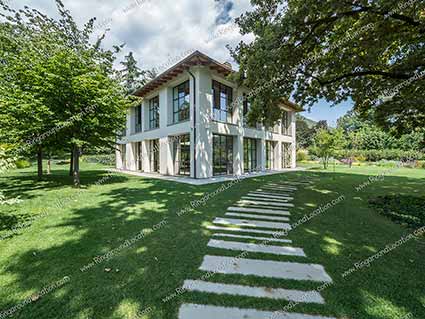 villa contemporanea con grandi vetrate vista giardino, arredi di design , minimal